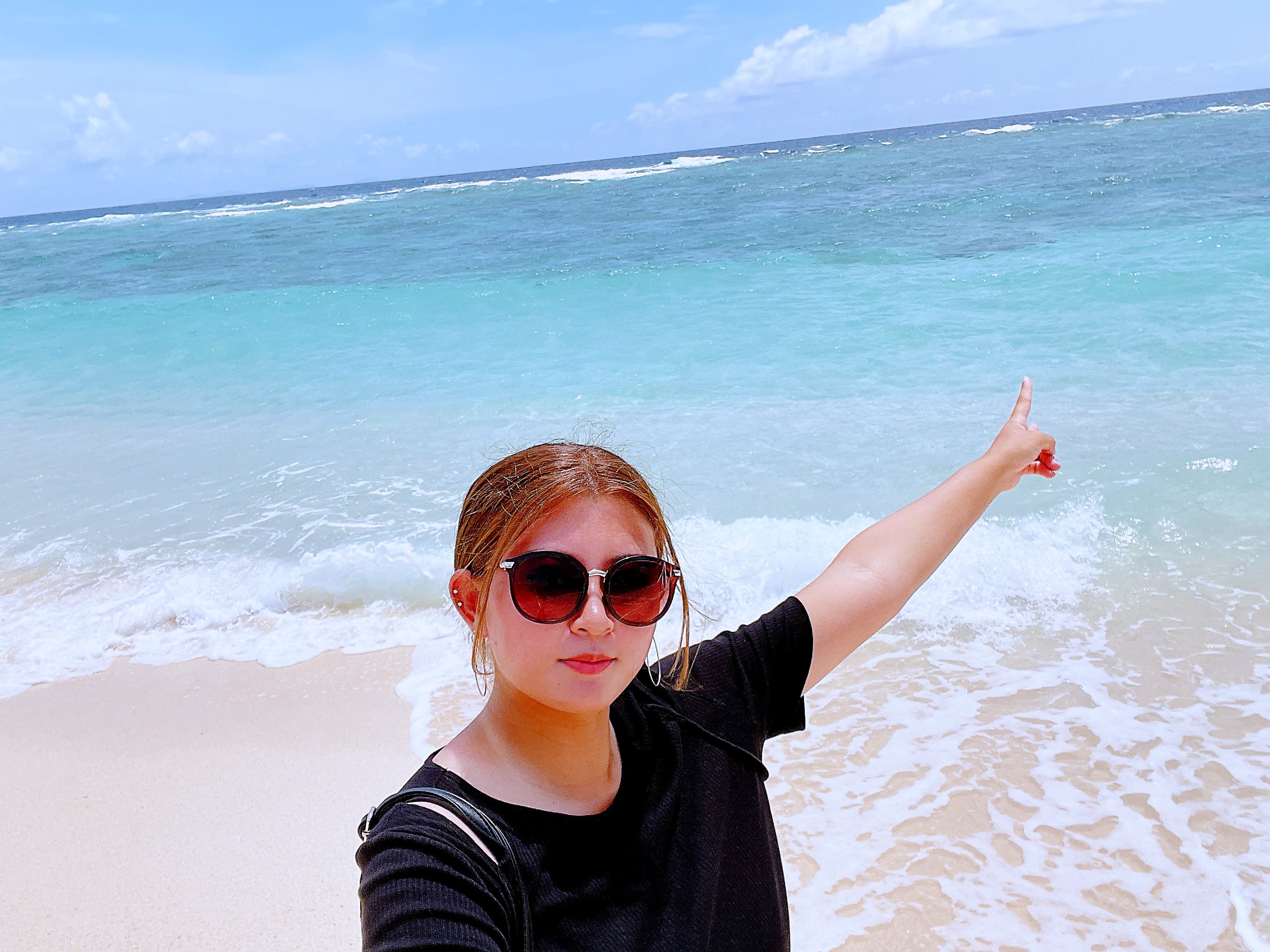 海とサングラスをかけている永野詩葉の写真
